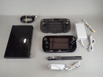 a nintendo wii game system sitting on a table next to a charger and a charger