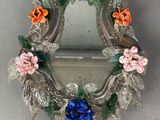 un petit miroir orné de fleurs, posé sur une table