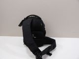 black backpack on a white table with a white wall in the background