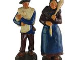 pair of figurines of two people holding a baseball bat and a ball