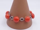 bracelet made of coral beads and diamonds on a brown cone