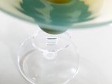 a glass vase with a flower inside of it on a table