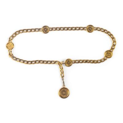un gros plan sur une ceinture en chaîne dorée ornée d'un pendentif en forme de pièce de monnaie