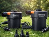 a couple of black and orange water pumps sitting on top of a lush green field