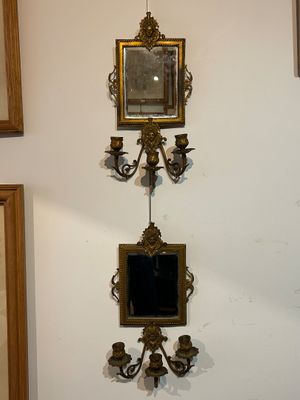a picture of a wall with a mirror and a candle holder on it