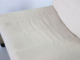 a white chair that has a white blanket on it
