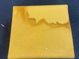 a close up of a piece of yellow plastic on a blue surface