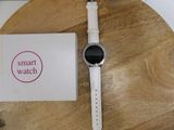 a smart watch sitting on a wooden table next to a box