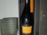 une bouteille de champagne posée dans une boîte sur une étagère