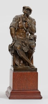 une statue en bronze représentant un homme assis sur un banc