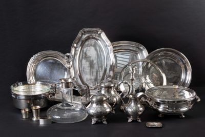 a lot of silver plates and bowls on the table