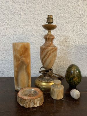 une table sur laquelle se trouvent une lampe, un bougeoir et d'autres objets