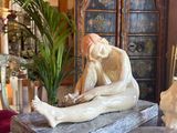 a statue of a man sitting on a table in a living room