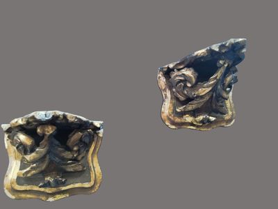 two pieces of bronze are shown on a gray surface