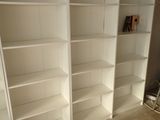 a white bookcase in the corner of a room