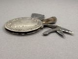 a silver coin and a pair of pliers on a table