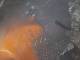 une substance orange dans une casserole d'eau bouillante