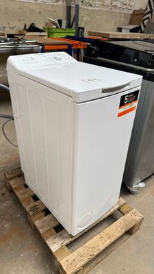 a white washing machine sitting on a pallet in a warehouse