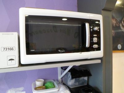 a microwave that is on a shelf in the kitchen