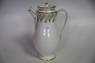une cafetière blanche et dorée posée sur une table blanche