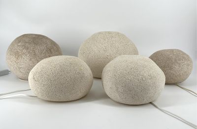 trois gros rochers blancs posés sur une table, à côté d'un ordinateur portable
