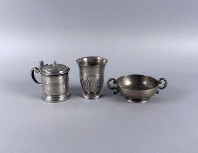 three silverplated cups and a saucer on a table