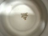 a close up of a white plate with a gold decoration