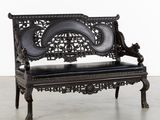 un banc noir posé sur un sol en béton