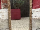 a mirror sitting on the ground next to a brick wall