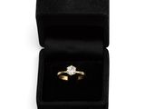 an engagement ring in a black velvet box with a diamond