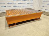 an orange metal table with a metal grate underneath it