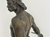 bronze statue of a man with a sword on a marble base
