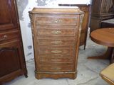 une haute commode en bois dans le coin d'une pièce