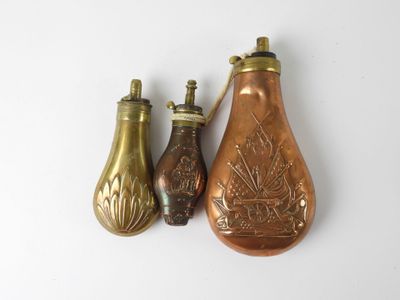 three antique brass vases are sitting next to each other on a white surface