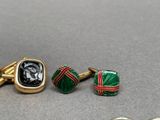 three pairs of cufflinks and a ring with a picture of a man