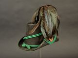 a brown hat with feathers on it on a stand