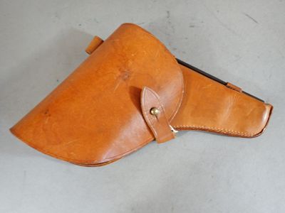 a close up of a brown leather holster on a white surface