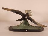 statue of an eagle flying over a mountain on a white background