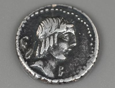 une pièce ancienne sur laquelle figurent une tête de femme et une plume