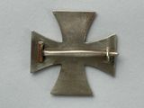an image of a metal cross on a white surface