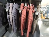 many jackets hanging on a rack in a store
