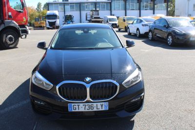 a black bmw car parked in a parking lot