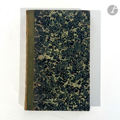 an old book sitting on top of a white table next to a white wall