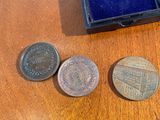 a small ring sitting on top of a wooden table next to some coins
