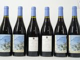 six bouteilles de vin sont alignées sur une table