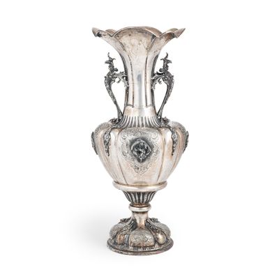un vase ancien en argent posé sur un socle en métal