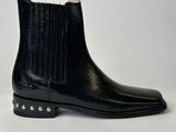 a pair of black leather boots with studded sides on a white background