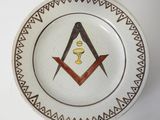 une assiette ornée d'un symbole maçonnique, posée sur une table