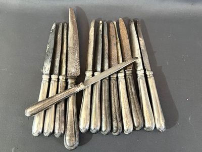six couteaux d'argenterie et un couteau sur une table