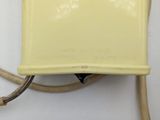 a yellow telephone that is connected to the wall